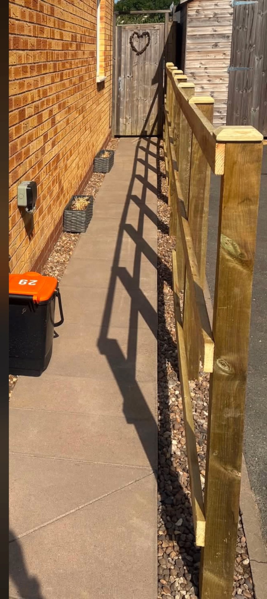 New trellis-topped timber fencing installed along a side path